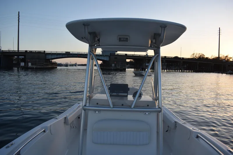 Slide: The Image of 2007 Tidewater 216 CC Adventure boat on water near a bridge at sunset. - 11