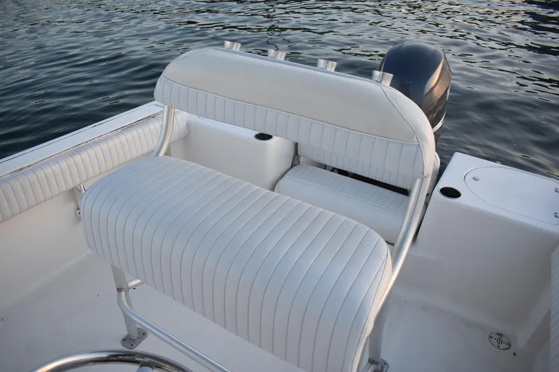 Slide: The Image of 2007 Tidewater 216 CC Adventure boat interior with white seating and water backdrop. - 17