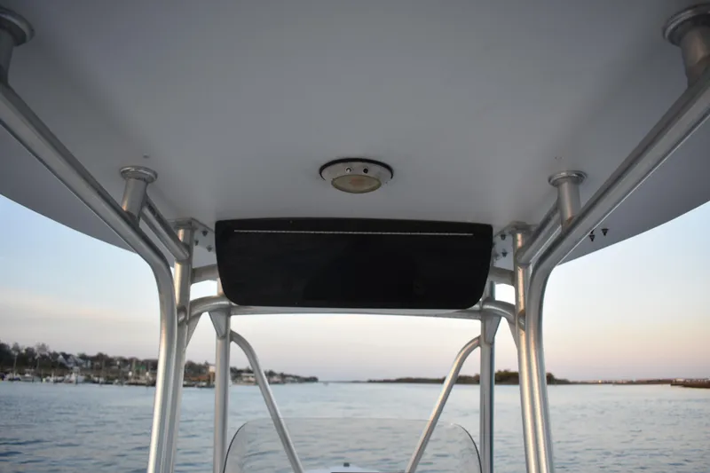 Slide: The Image of Tidewater 216 CC Adventure boat interior view, showcasing T-top structure over calm waters. - 19