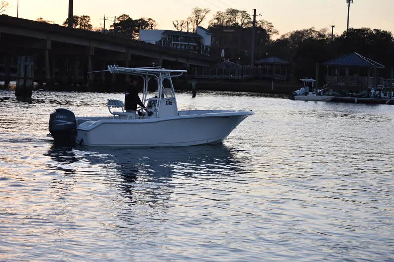 Slide: The Image of 2007 Tidewater 216 CC Adventure boat cruising near a bridge at sunset. - 2