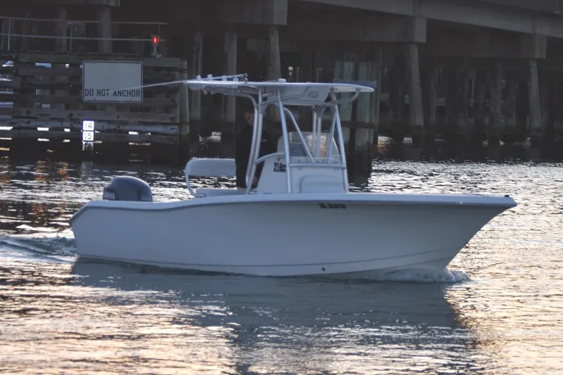 Slide: The Image of 2007 Tidewater 216 CC Adventure boat cruising near a bridge. - 2