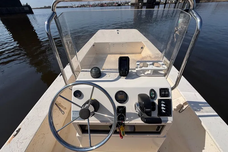 Slide: The Image of 2005 Jones Brothers Bateau 20 boat console with steering wheel and controls on calm water. - 12