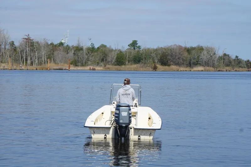 Slide: The Image of 2005 Jones Brothers Bateau 20 boat on calm water, with trees in the background. - 7
