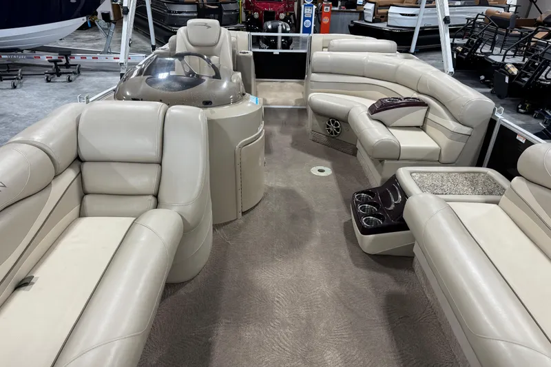 Slide: The Image of 2010 Bennington 2250 RCW pontoon boat interior with beige seating and cup holders. - 10