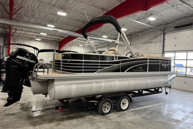 Slide: The Image of 2010 Bennington 2250 RCW pontoon boat in a garage, featuring a Mercury outboard motor. - 4
