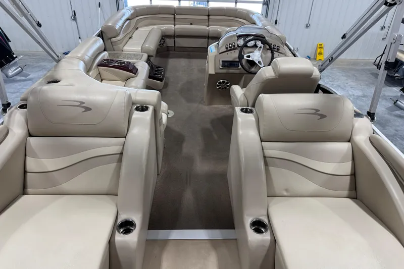 Slide: The Image of Interior of a 2010 Bennington 2250 RCW pontoon boat with beige seating and steering console. - 7