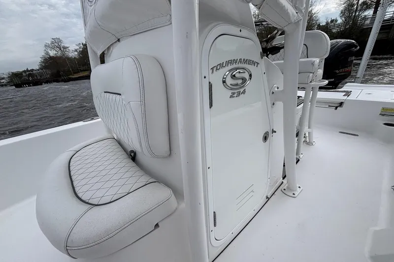 Slide: The Image of 2021 Sportsman Tournament 234 Bay Boat interior with white seating and storage compartment. - 10