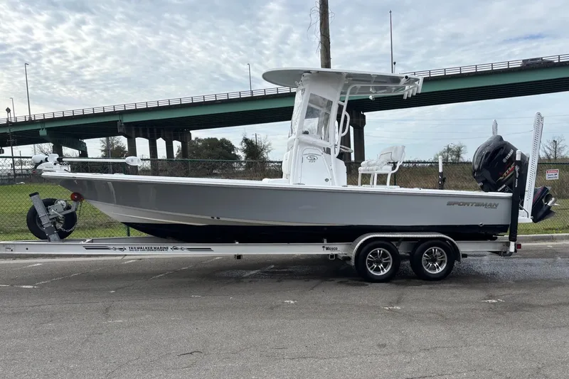 Slide: The Image of 2021 Sportsman Tournament 234 Bay Boat on trailer, parked near highway overpass. - 12