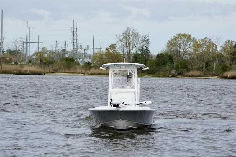 Slide: The Image of 2021 Sportsman Tournament 234 Bay Boat navigating a river with trees in the background. - 6
