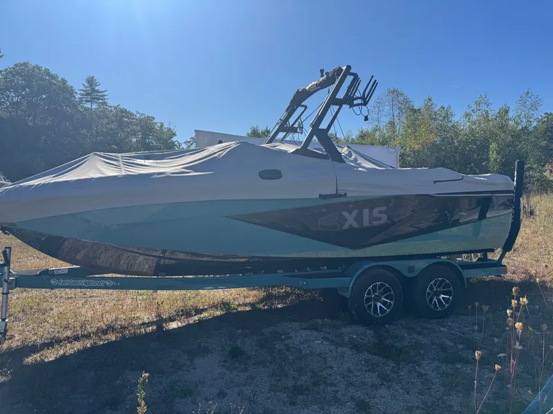 The Image of 2024 Axis T220 boat with cover on trailer outdoors. - 1
