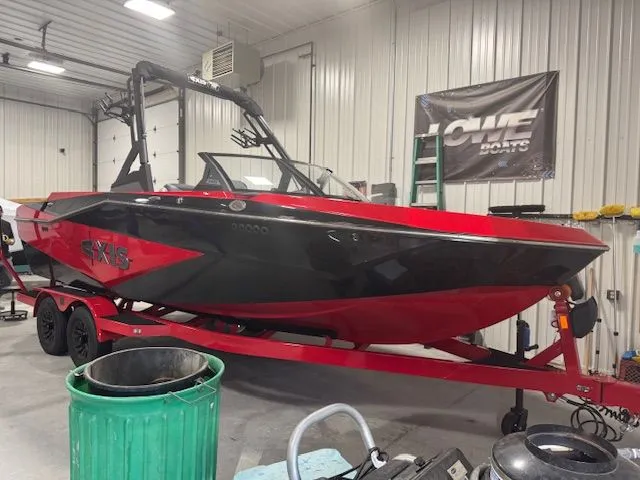 The Image of 2025 Axis T220 boat in black and red in a workshop. - 1