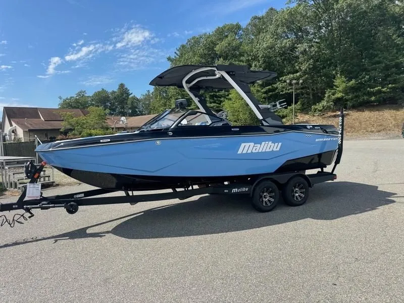 Slide: The Image of 2026 Malibu Wakesetter 22 LSV boat on trailer, blue hull, sunny day. - 3