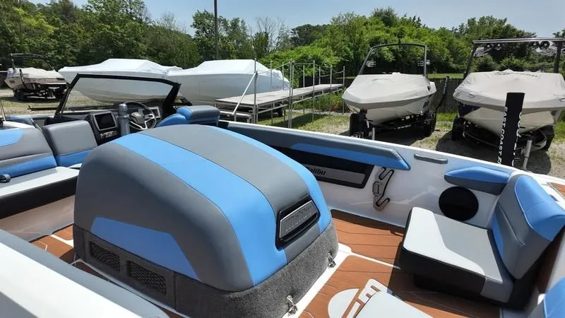 Slide: The Image of Interior of a 2025 Malibu TXi boat with blue and gray seating. - 12