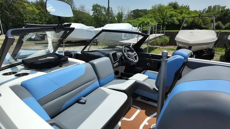 Slide: The Image of Interior of a 2025 Malibu TXi boat with blue and gray seating. - 13