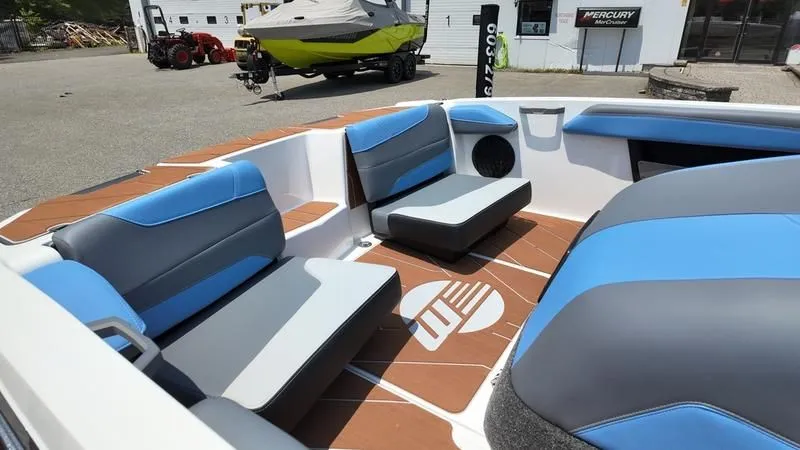 Slide: The Image of Interior of a 2025 Malibu TXi boat with blue and gray seating. - 9