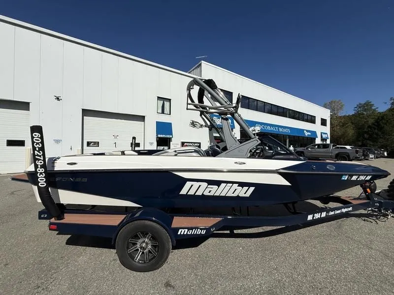 Slide: The Image of 2024 Malibu TXi boat parked in front of a building. - 24