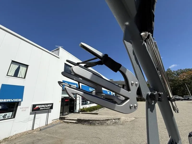 Slide: The Image of Malibu TXi 2024 boat with wakeboard rack in front of service building. - 26