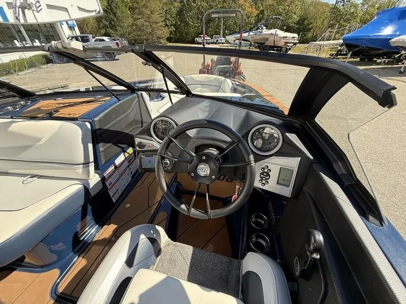 Slide: The Image of Interior view of 2024 Malibu TXi boat cockpit with steering wheel and instruments. - 5