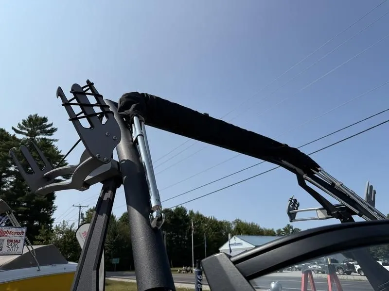 Slide: The Image of Malibu TXi 2022 boat with wakeboard rack and blue sky. - 15
