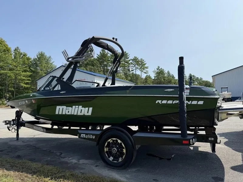Slide: The Image of 2022 Malibu TXi boat parked on trailer outdoors. - 3