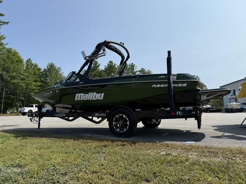 Slide: The Image of 2022 Malibu TXi boat parked outdoors on a trailer. - 5