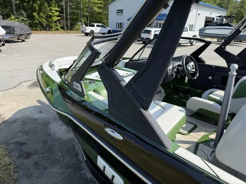 Slide: The Image of 2022 Malibu TXi boat with green interior on parking lot. - 7