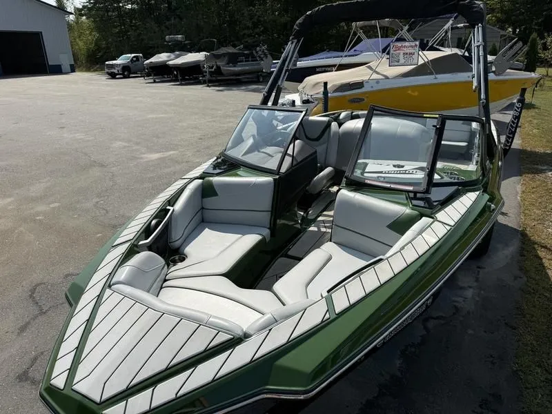 Slide: The Image of Green 2022 Malibu TXi boat with open cockpit on parking lot. - 9