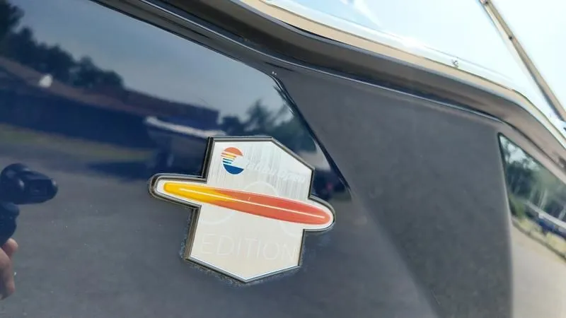 Slide: The Image of Malibu TXi 2025 emblem on glossy black surface. - 29