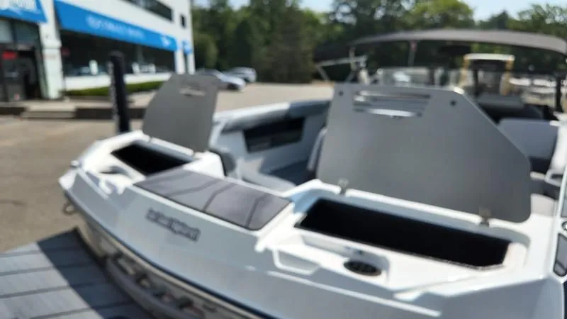 Slide: The Image of 2025 Malibu TXi boat with open storage compartments outdoors. - 33