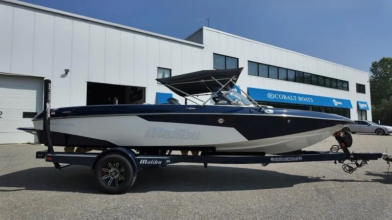 Slide: The Image of 2025 Malibu TXi boat on trailer in front of Cobalt Boats building. - 4