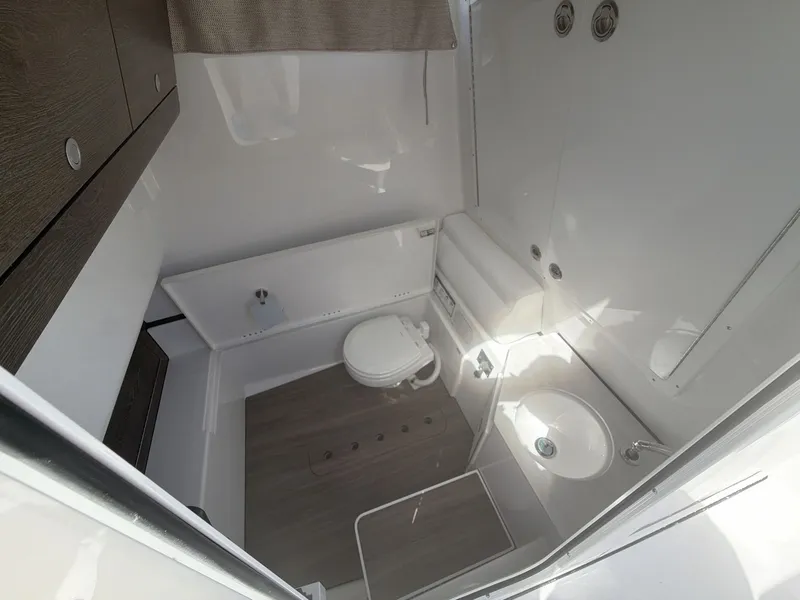 Slide: The Image of Interior of 2026 Sportsman Open 322 Center Console with toilet and sink. - 12