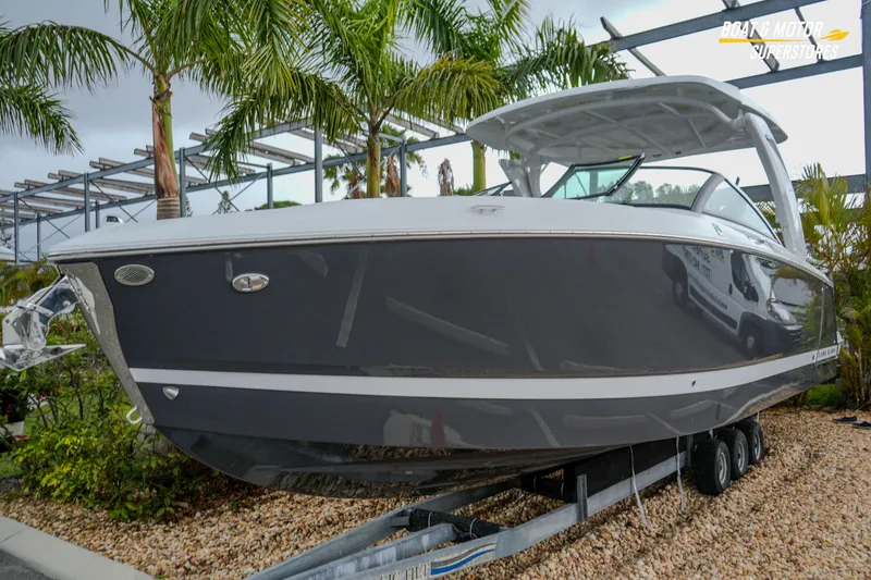 Slide: The Image of 2026 Four Winns H9 OB boat on trailer, surrounded by palm trees. - 11