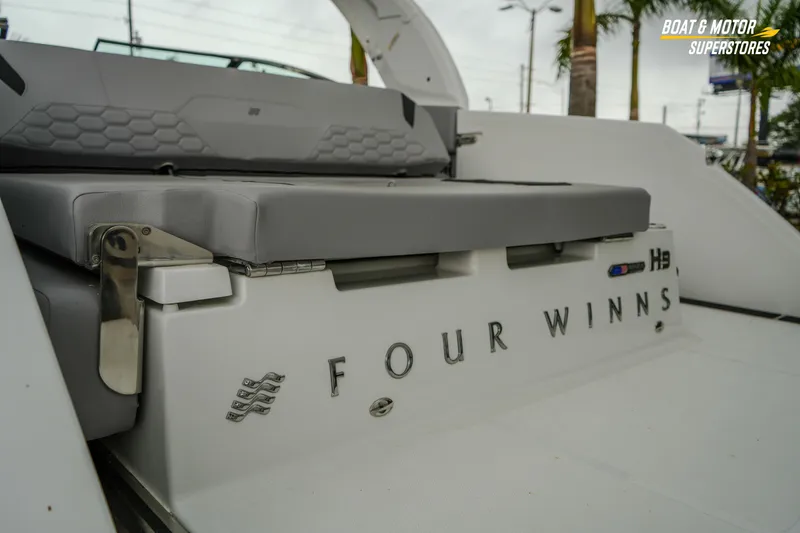 Slide: The Image of 2026 Four Winns H9 OB boat rear view with seating and branding details. - 18