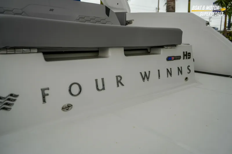 Slide: The Image of 2026 Four Winns H9 OB boat rear view with logo and seating detail. - 20