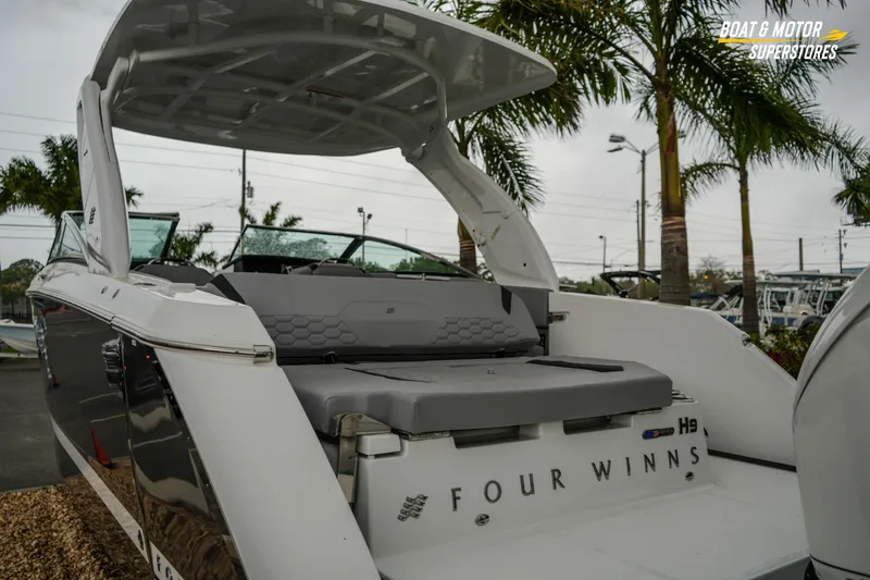 Slide: The Image of 2026 Four Winns H9 OB boat with sleek design, showcased at a dealership. - 22