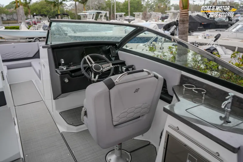 Slide: The Image of 2026 Four Winns H9 OB boat interior with steering wheel and seating area. - 32