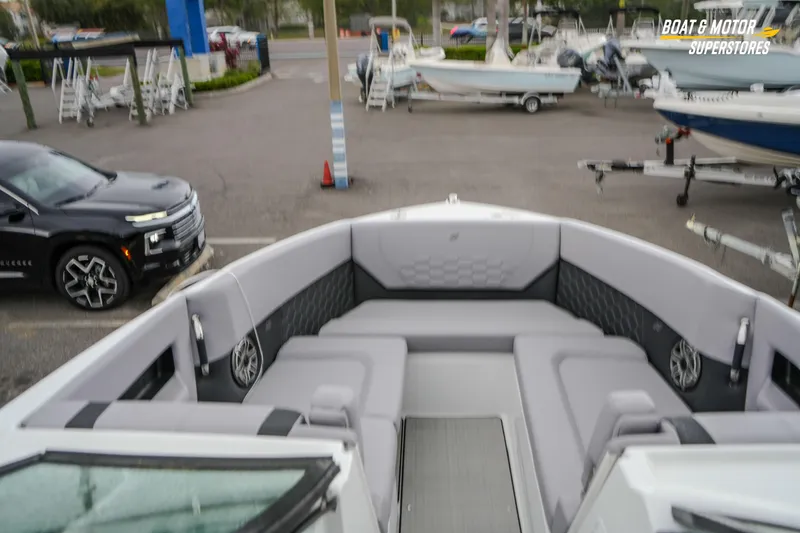 Slide: The Image of 2026 Four Winns H9 OB boat interior with gray seating, parked in a dealership lot. - 35