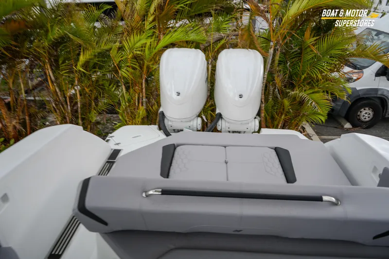 Slide: The Image of 2026 Four Winns H9 OB boat with dual outboard motors, surrounded by lush greenery. - 43
