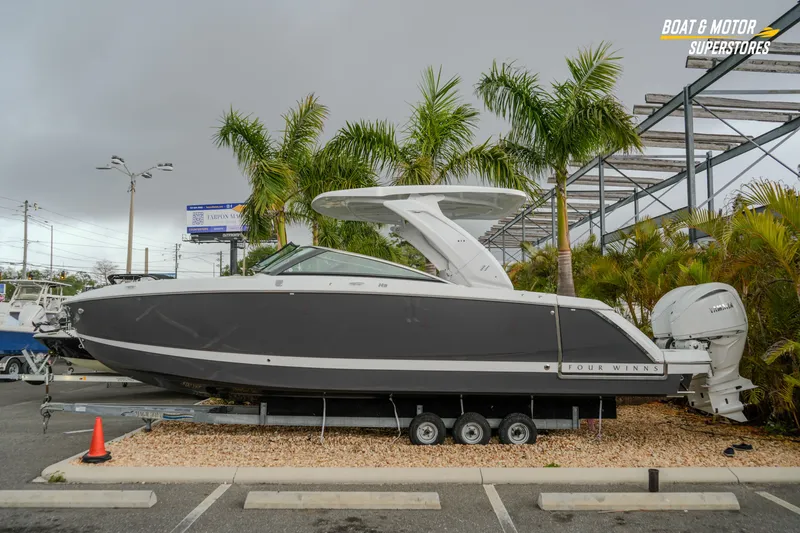 The Image of 2026 Four Winns H9 OB boat displayed outdoors with palm trees in the background. - 8