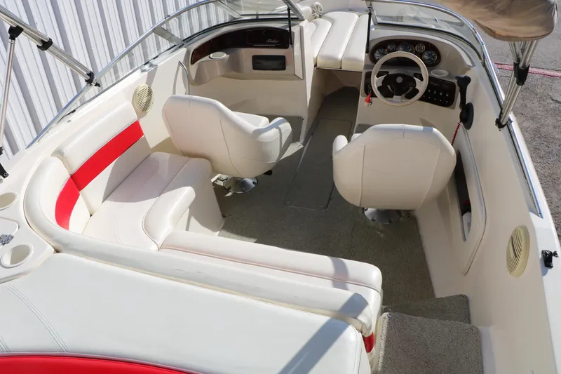 Slide: The Image of 2002 Rinker 192 Captiva Bowrider interior with white and red seating, steering wheel, and dashboard. - 17