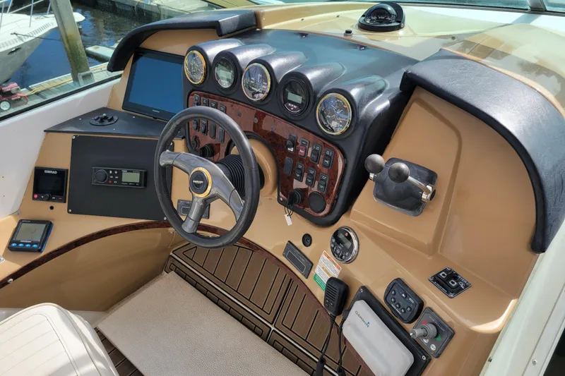 Slide: The Image of 2001 Carver 570 Voyager Pilothouse helm with gauges, steering wheel, and navigation controls. - 100