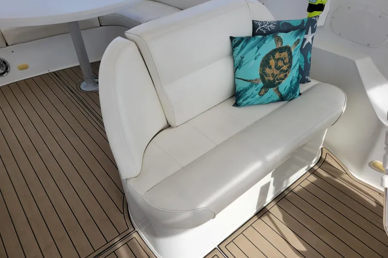 Slide: The Image of White seating with turtle-themed cushion on 2001 Carver 570 Voyager Pilothouse yacht deck. - 101