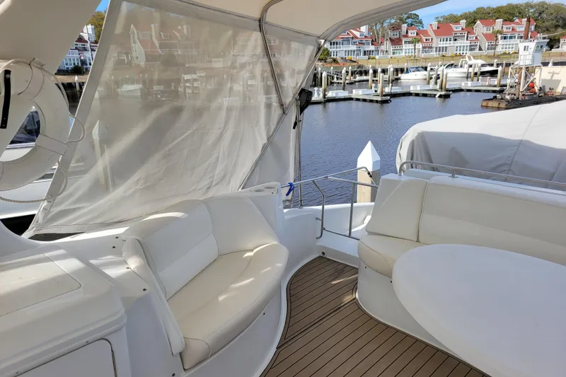 Slide: The Image of 2001 Carver 570 Voyager Pilothouse yacht interior with white seating and waterfront view. - 103