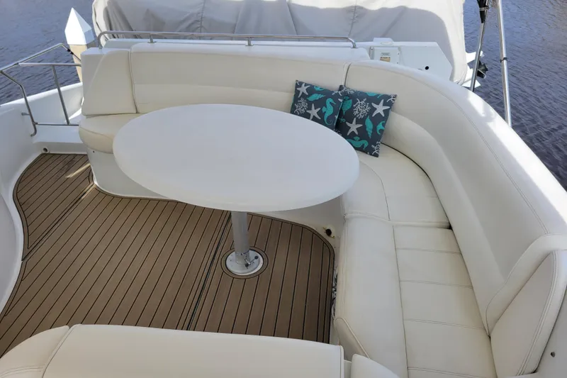 Slide: The Image of Luxurious seating area on 2001 Carver 570 Voyager Pilothouse yacht with white cushions and table. - 104