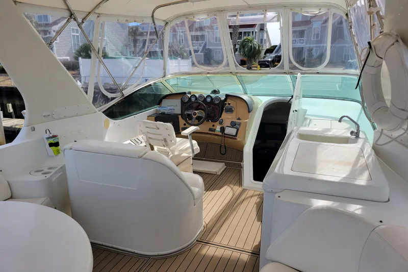 Slide: The Image of 2001 Carver 570 Voyager Pilothouse interior with helm, seating, and sink. - 107