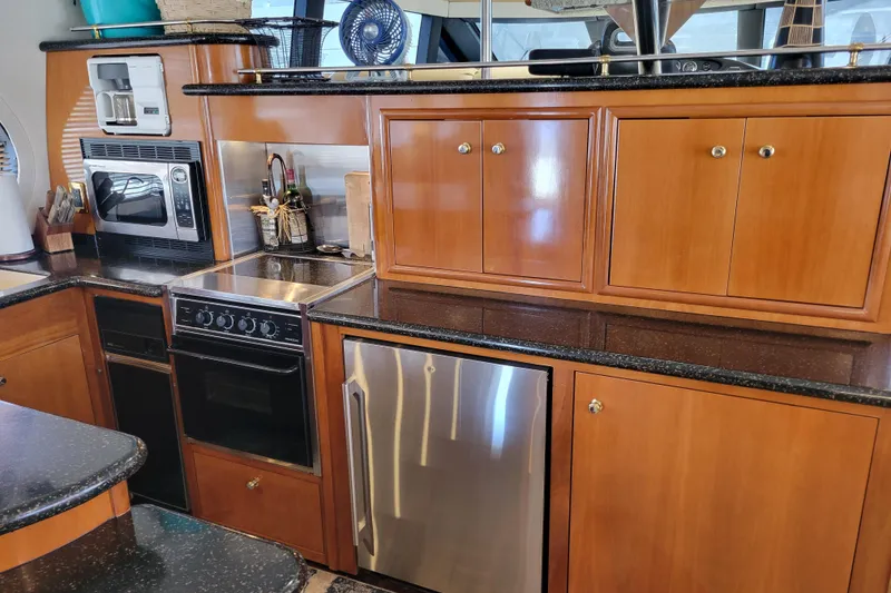 Slide: The Image of Luxurious kitchen in 2001 Carver 570 Voyager Pilothouse with modern appliances and wood cabinetry. - 11