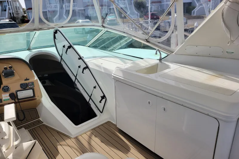 Slide: The Image of 2001 Carver 570 Voyager Pilothouse interior with helm, hatch, and sink area. - 111