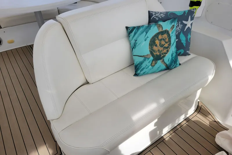 Slide: The Image of White leather seating with turtle-themed pillows on 2001 Carver 570 Voyager Pilothouse yacht. - 115