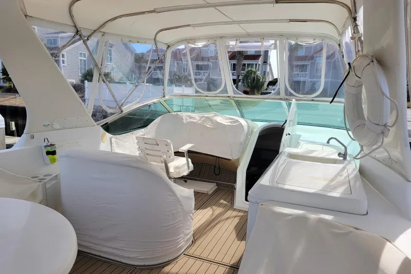 Slide: The Image of 2001 Carver 570 Voyager Pilothouse interior with covered seating and helm station. - 122