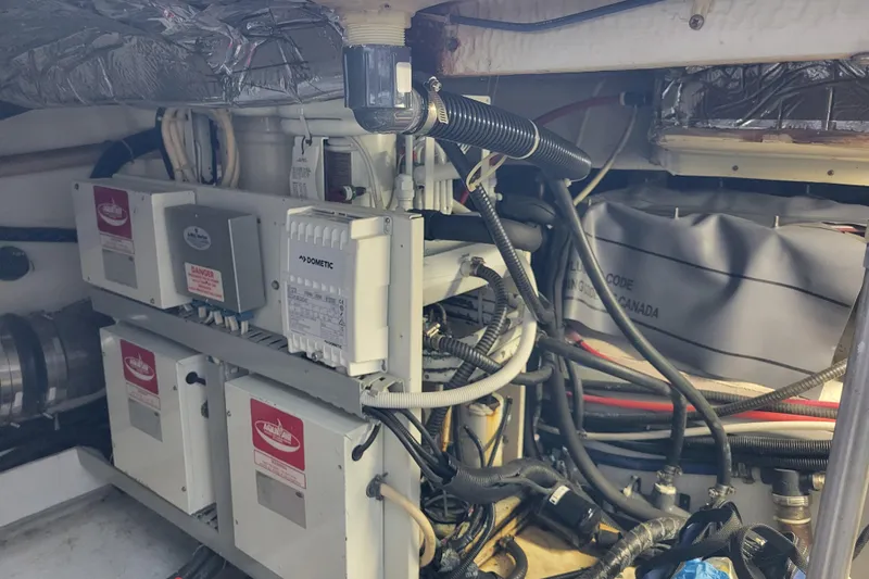 Slide: The Image of Engine room of a 2001 Carver 570 Voyager Pilothouse with electrical components and wiring. - 133